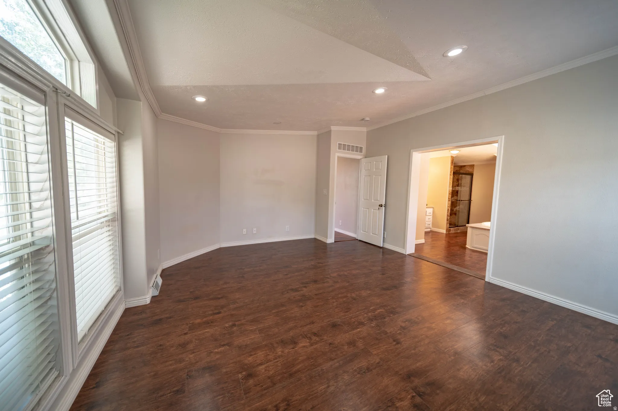 Large Master bedroom featuring crown molding, dark wood-type flooring, recessed lighting, and vaulted ceiling