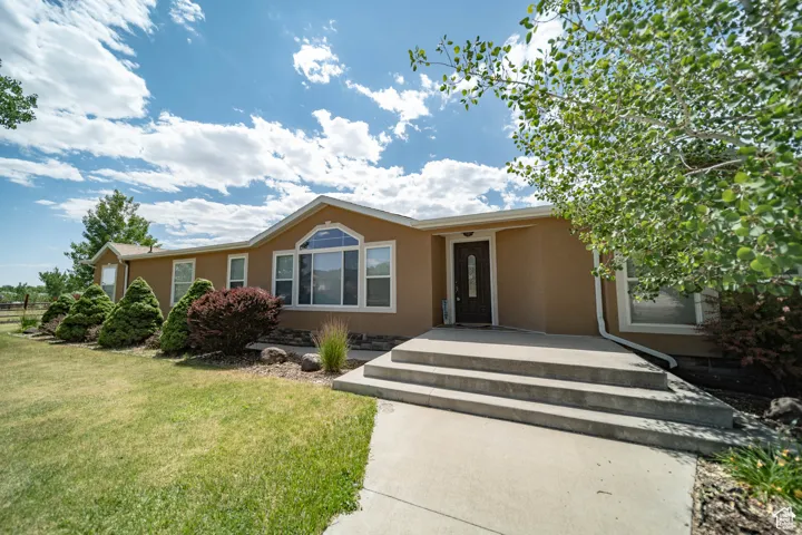 Ranch-style house with stucco siding and a front yard