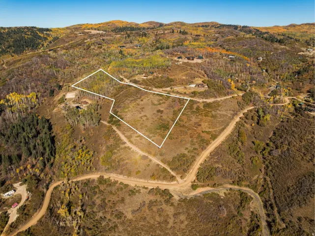 Aerial overview of property's location featuring property boundaries highlighted and a mountainous background