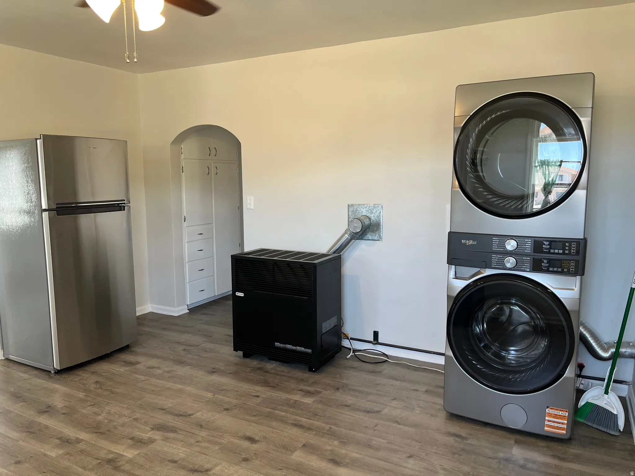 Stainless steel stackable laundry appliances complemented by wood-finish flooring