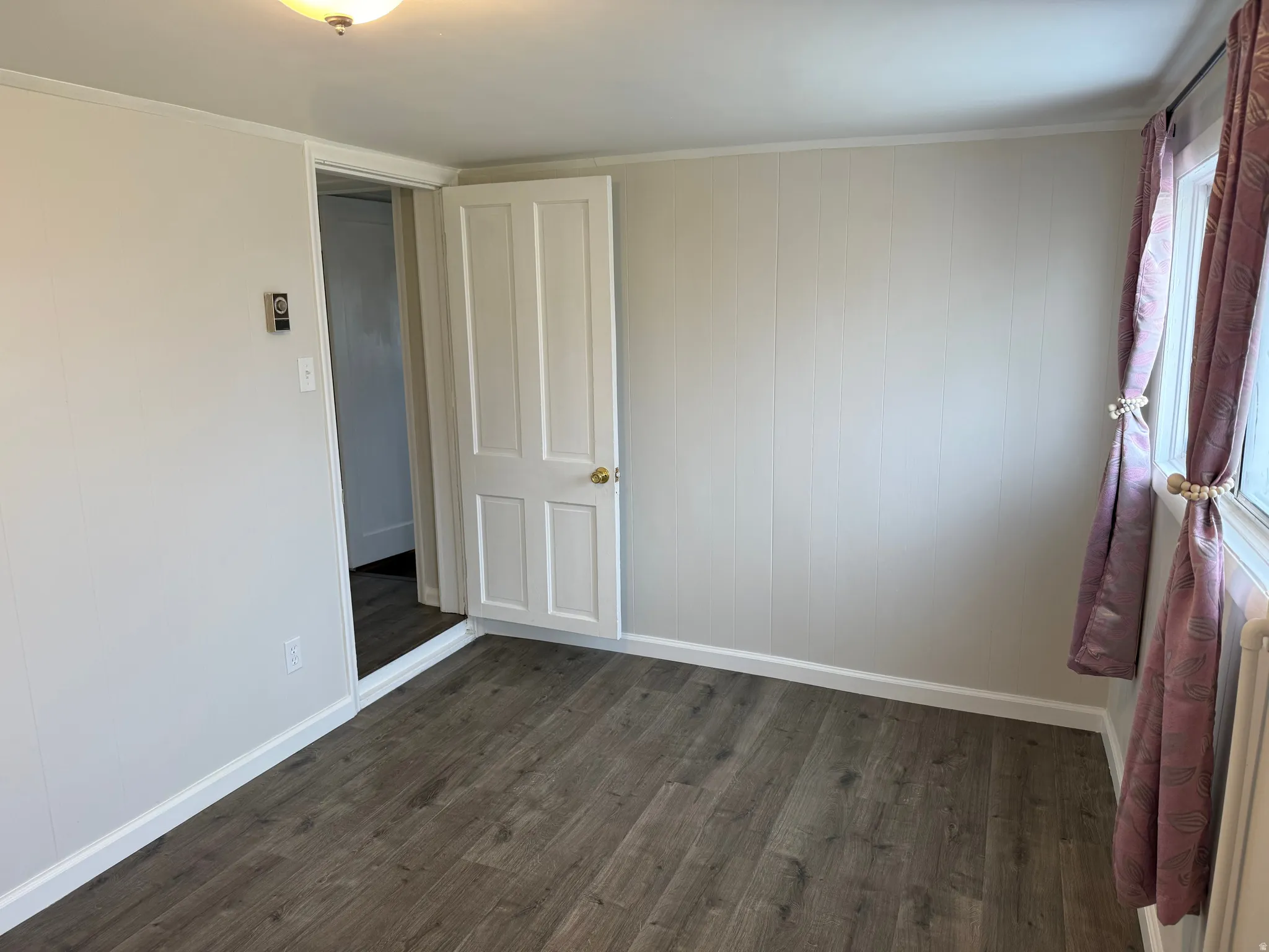 Unfurnished room featuring dark wood finished floors and crown molding