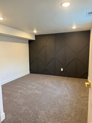 Below grade area featuring carpet, a textured ceiling, and recessed lighting