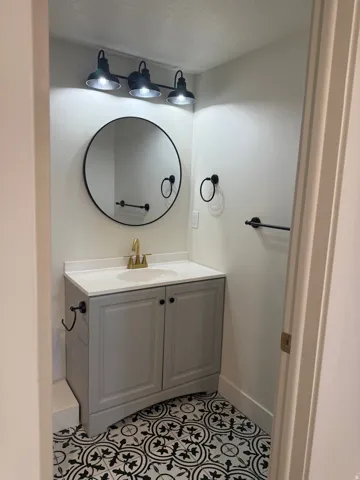 Bathroom featuring vanity, light tile patterned floors, and a textured ceiling
