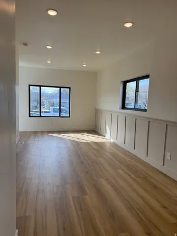 Empty room with dark wood-style flooring and recessed lighting