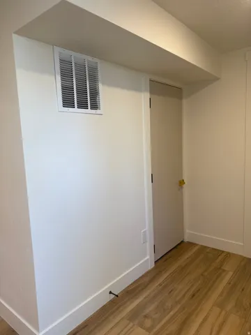 Finished below grade area featuring light wood-type flooring and baseboards