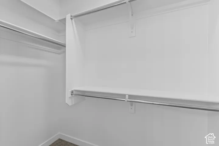 White closet featuring a built-in shelf and chrome hanging rods