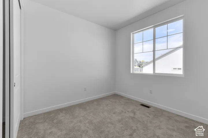 Carpeted flooring, white walls, white trim, and a multi-pane window