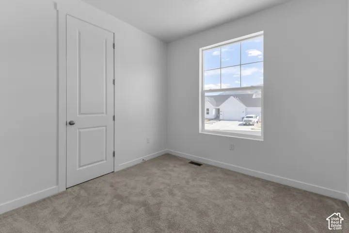 Carpeted flooring, white interior walls, white trim, and a window with a multi-pane grid