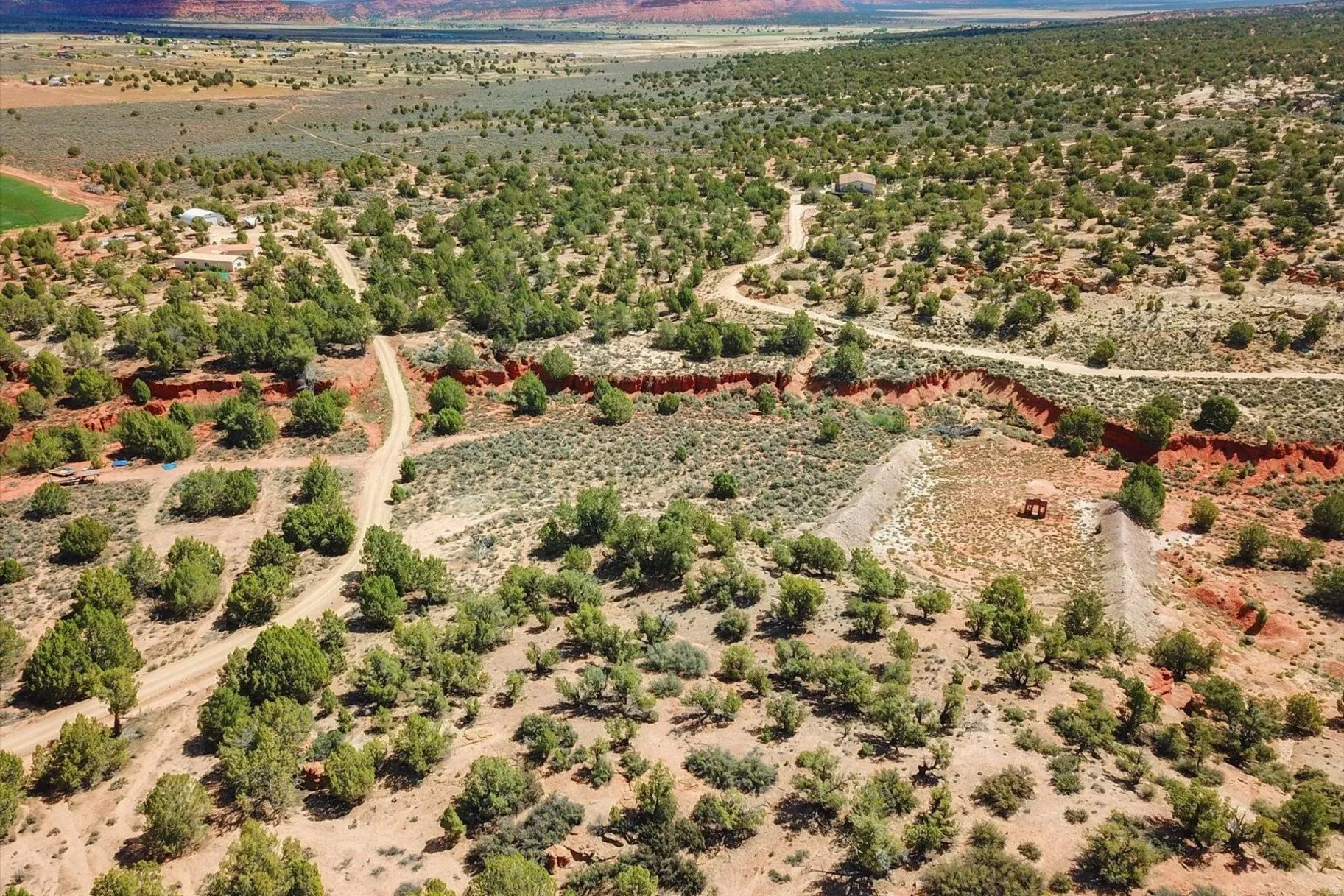 Extensive land featuring varied topography, desert vegetation, and unpaved access roads