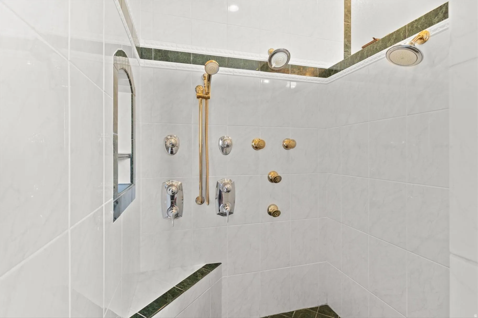 Tiled shower with multiple showerheads, body spray jets, and a handheld shower wand
