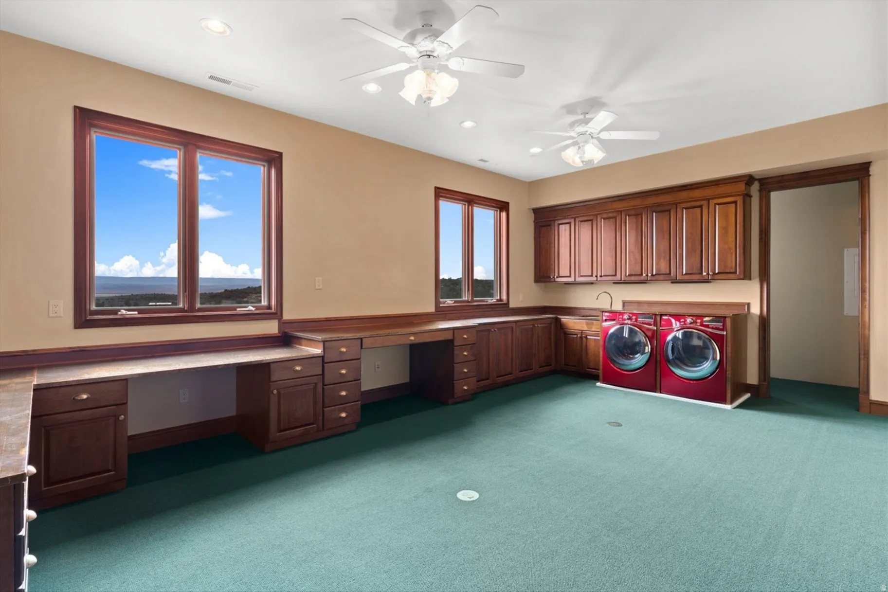 Integrated laundry area with built-in cabinetry and sink
