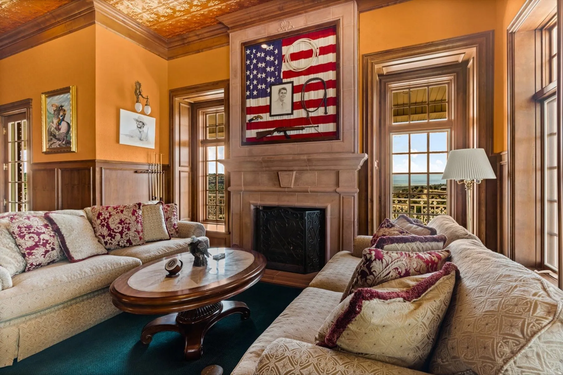 Detailed wood paneling, textured ceiling, stone-clad fireplace, and multiple windows with wood trim