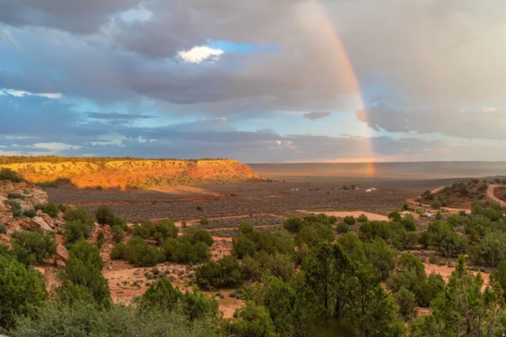Expansive desert landscape featuring rugged terrain and distant mesa formations