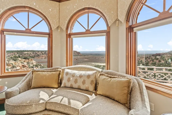 Curved seating area featuring three arched windows with wood trim