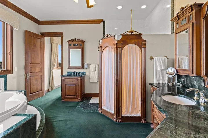 Dual vanity with dark green stone countertops and undermount sinks