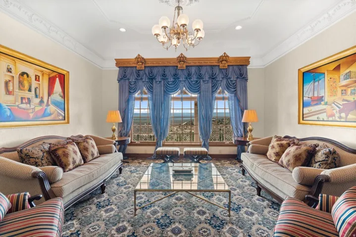 Ornate window treatments, decorative crown molding, intricate ceiling medallion, chandelier lighting, and patterned flooring