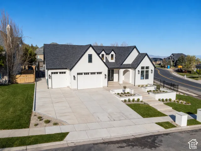 View of front of home featuring driveway, a shingled roof, a garage, and covered porch