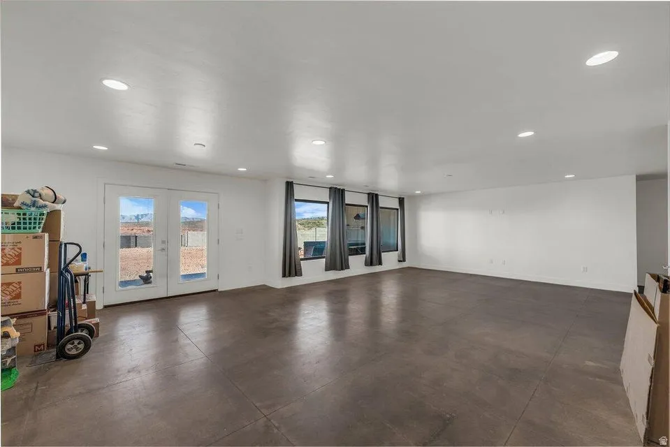 Spare room with concrete flooring, french doors, and recessed lighting