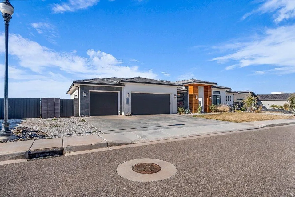 Prairie-style house with a garage, concrete driveway, and stucco siding