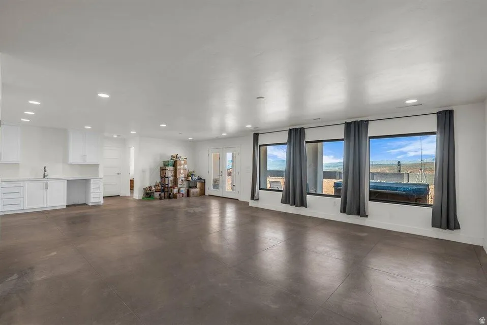 Unfurnished living room featuring recessed lighting and concrete floors