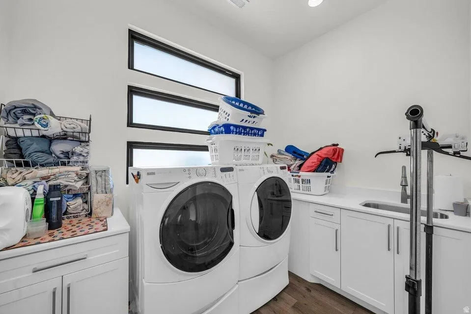 Laundry area with cabinet space, washing machine and dryer, and dark wood-type flooring