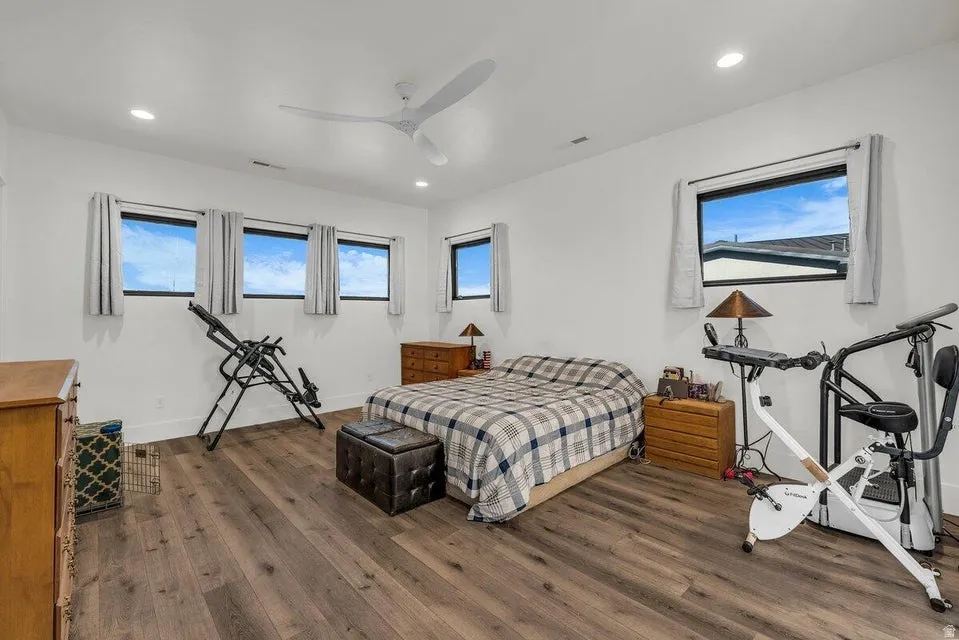 Bedroom with dark wood-style flooring, a ceiling fan, and recessed lighting