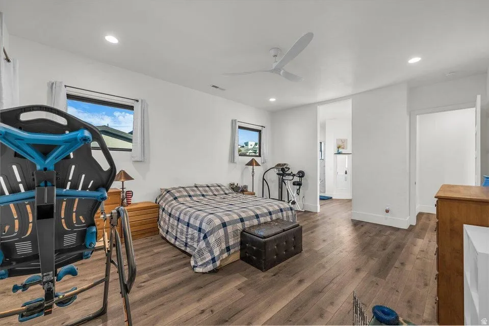 Bedroom featuring wood-type flooring, ceiling fan, recessed lighting, and ensuite bath
