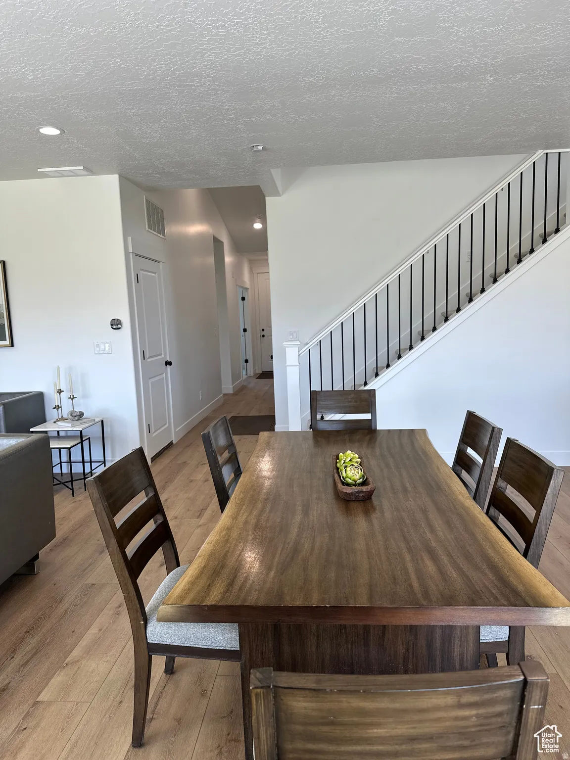 Dining area featuring light wood-style floors, a textured ceiling, and recessed lighting