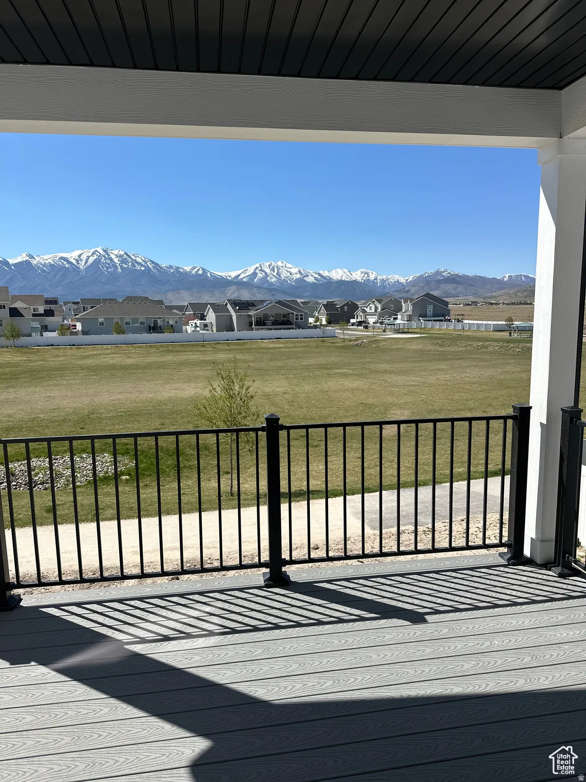 Deck with a residential view, a lawn, and a mountain view