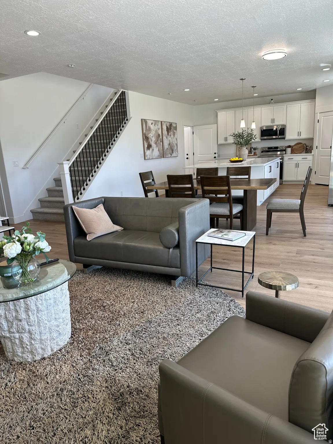 Living room featuring light wood-style flooring, recessed lighting, and a textured ceiling