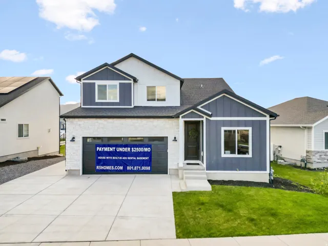 View of front of property featuring a front yard, board and batten siding, a garage, concrete driveway, and a shingled roof