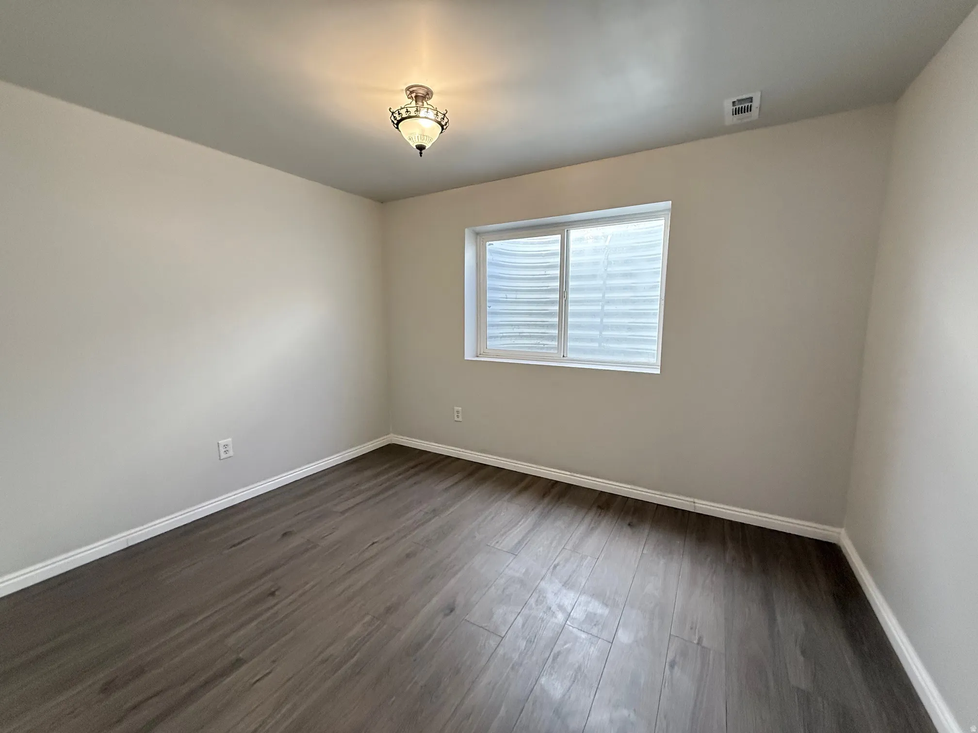 Unfurnished room with baseboards and dark wood finished floors