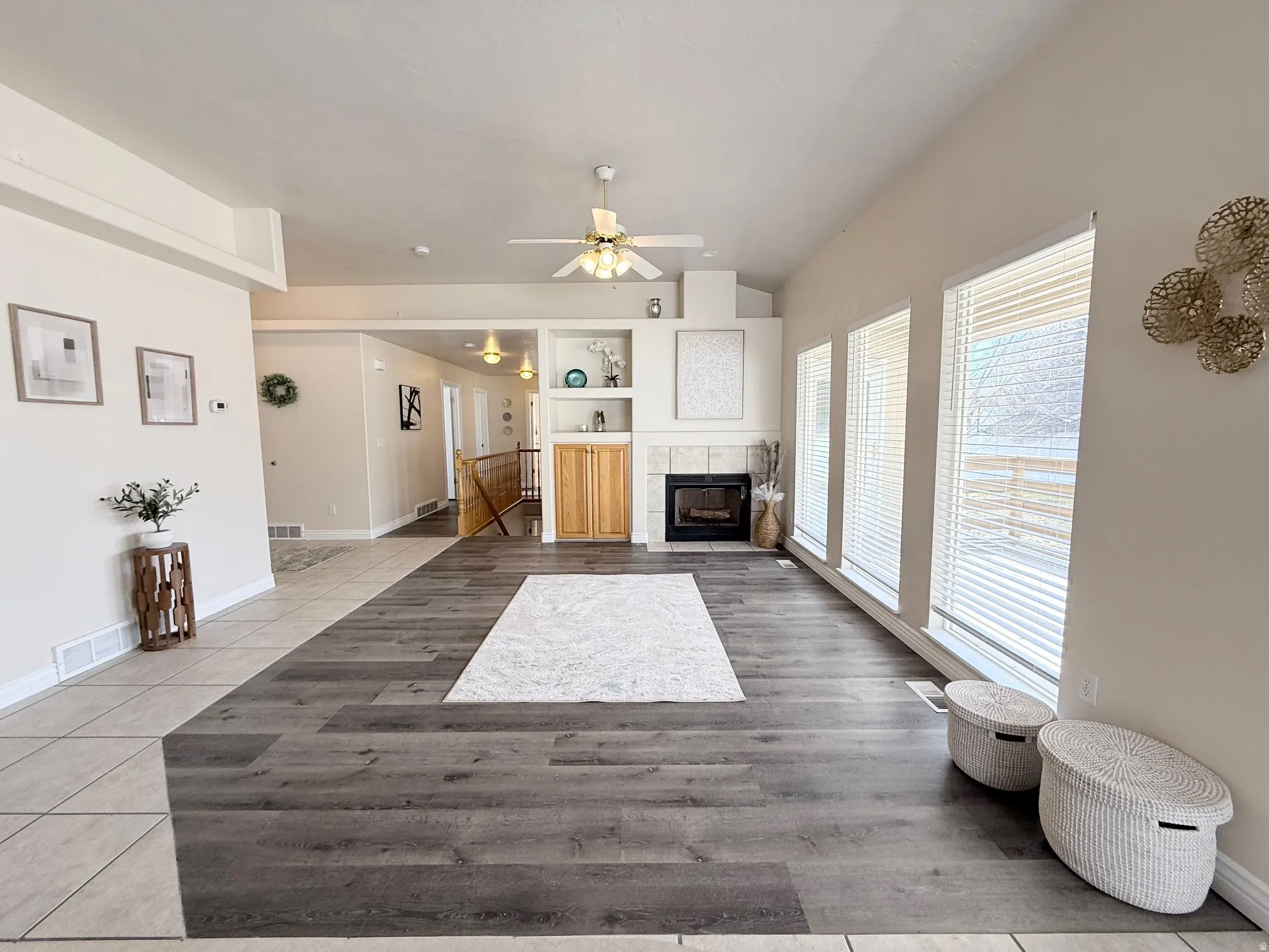 Living room featuring a ceiling fan, a fireplace, and light tile patterned floors
