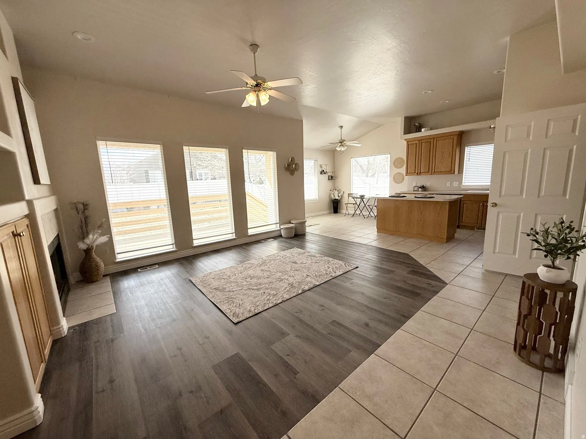 Unfurnished living room with lofted ceiling, light tile patterned flooring, and a ceiling fan