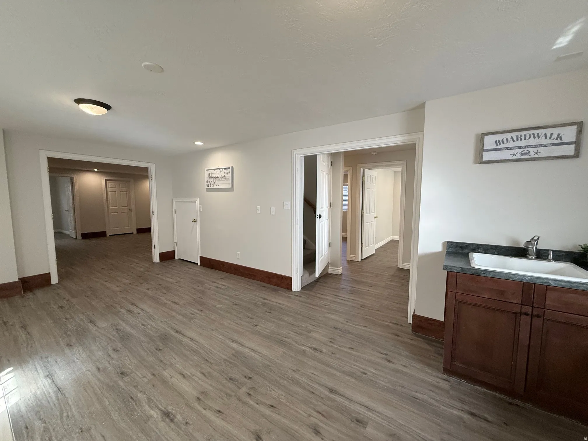 Living room with dark wood-type flooring and baseboards