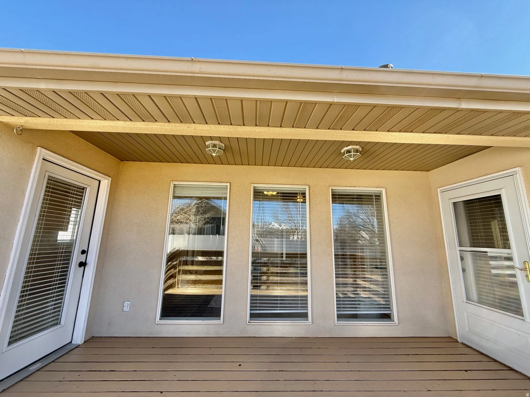 Entrance to property featuring stucco siding and a deck