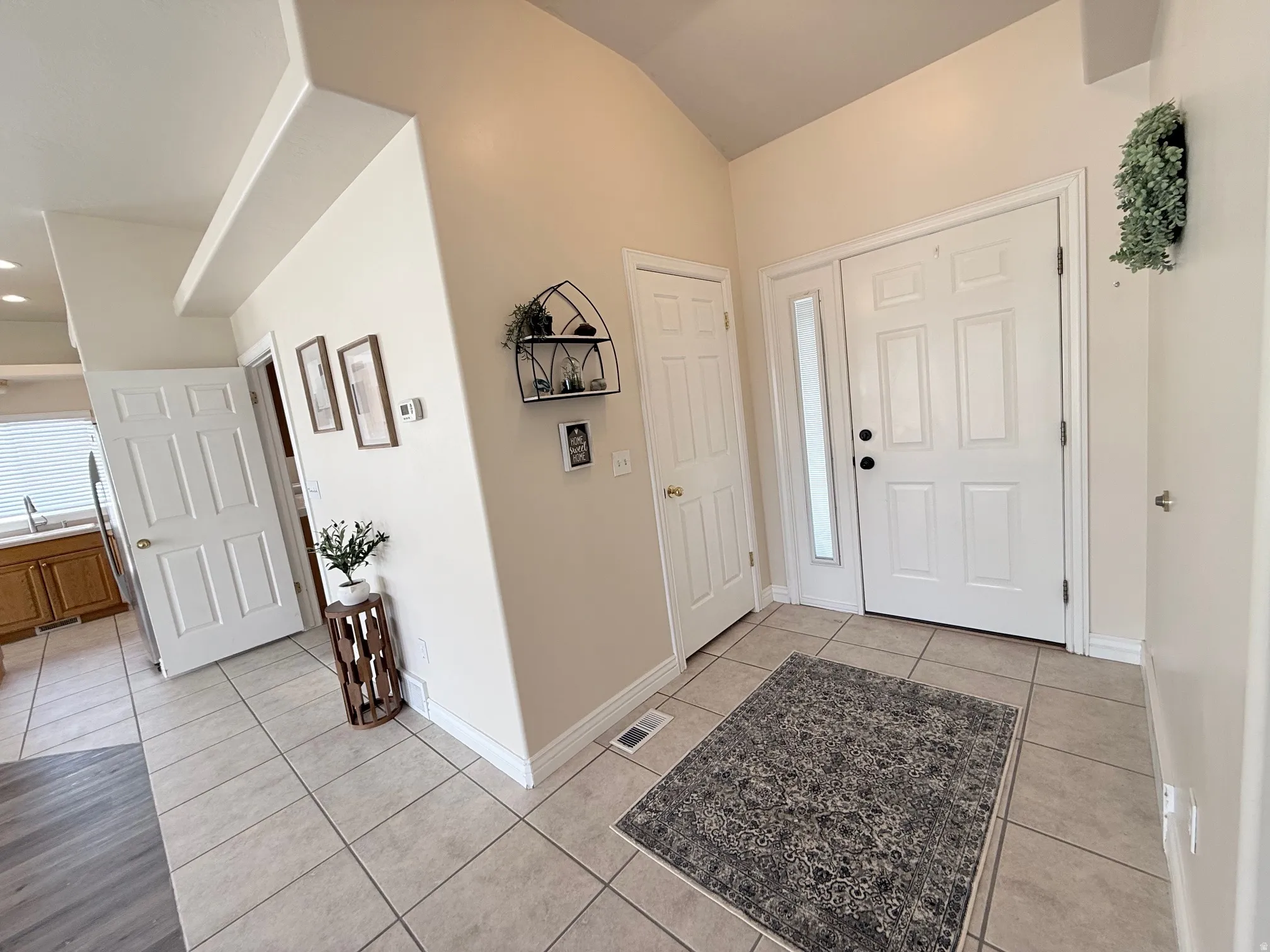 Entrance foyer featuring light tile patterned flooring and lofted ceiling