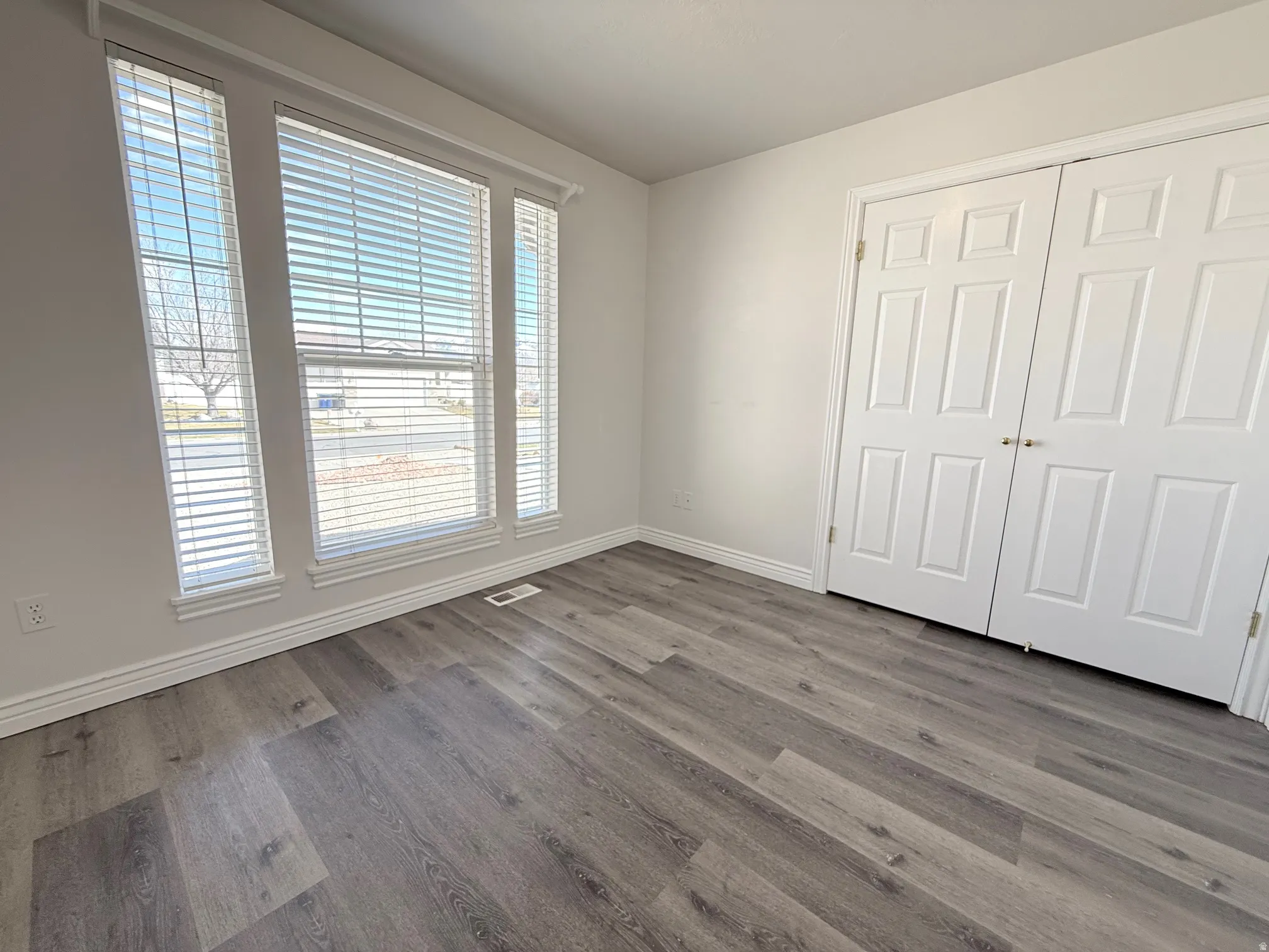 Unfurnished bedroom featuring dark wood finished floors and a closet