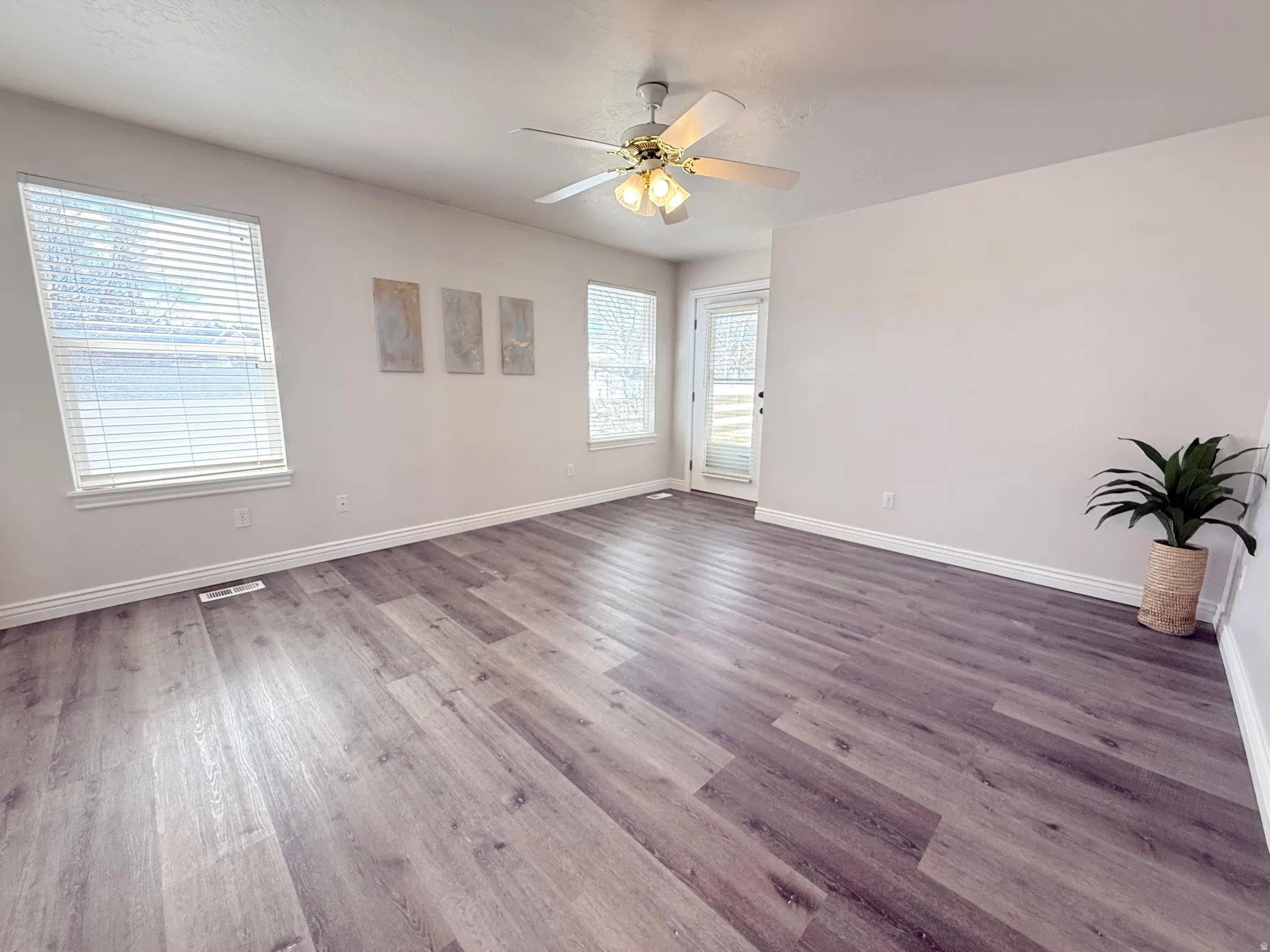 Spare room with a ceiling fan and dark wood-style floors