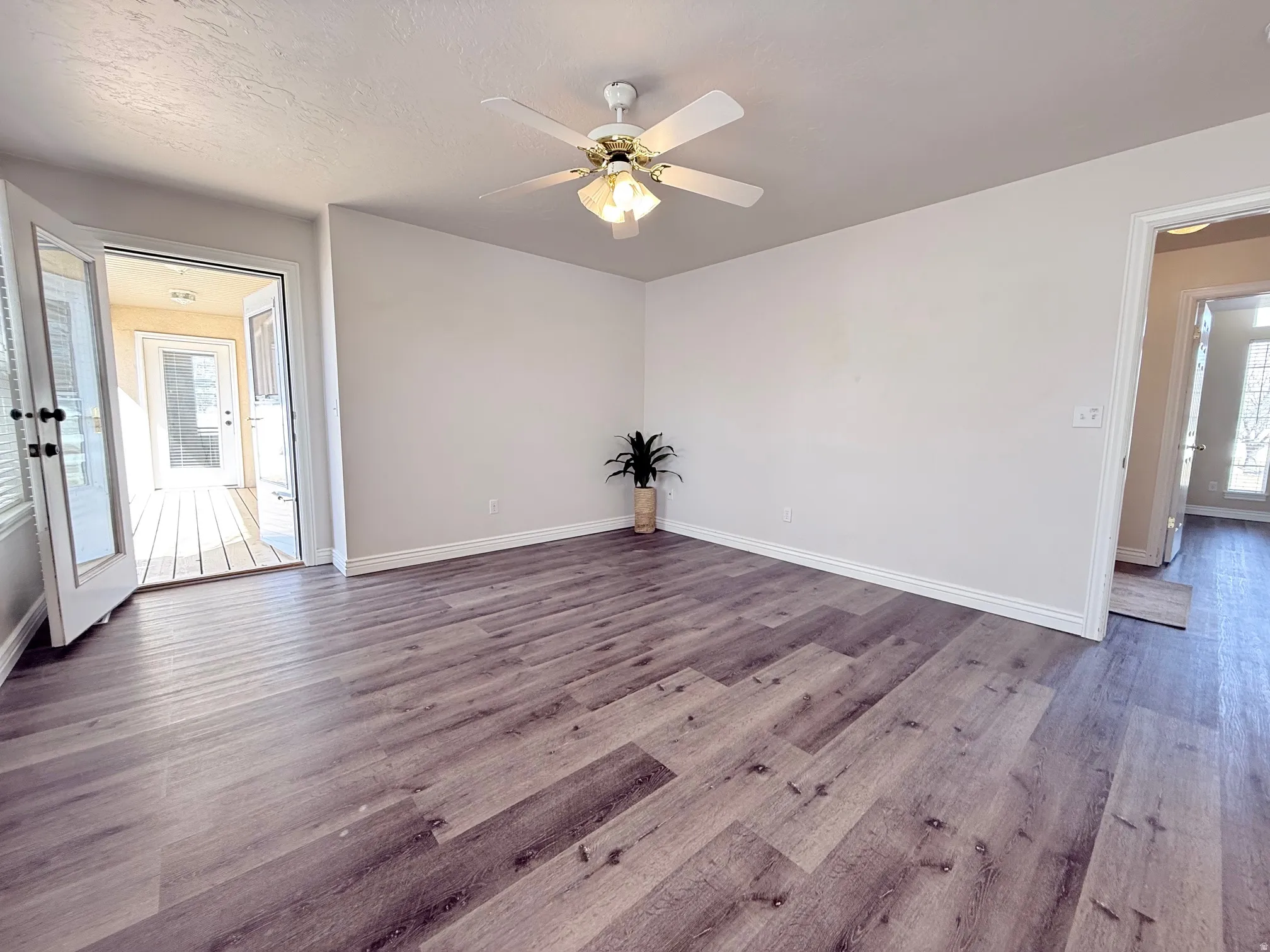 Spare room featuring a ceiling fan, dark wood-style flooring, and a textured ceiling