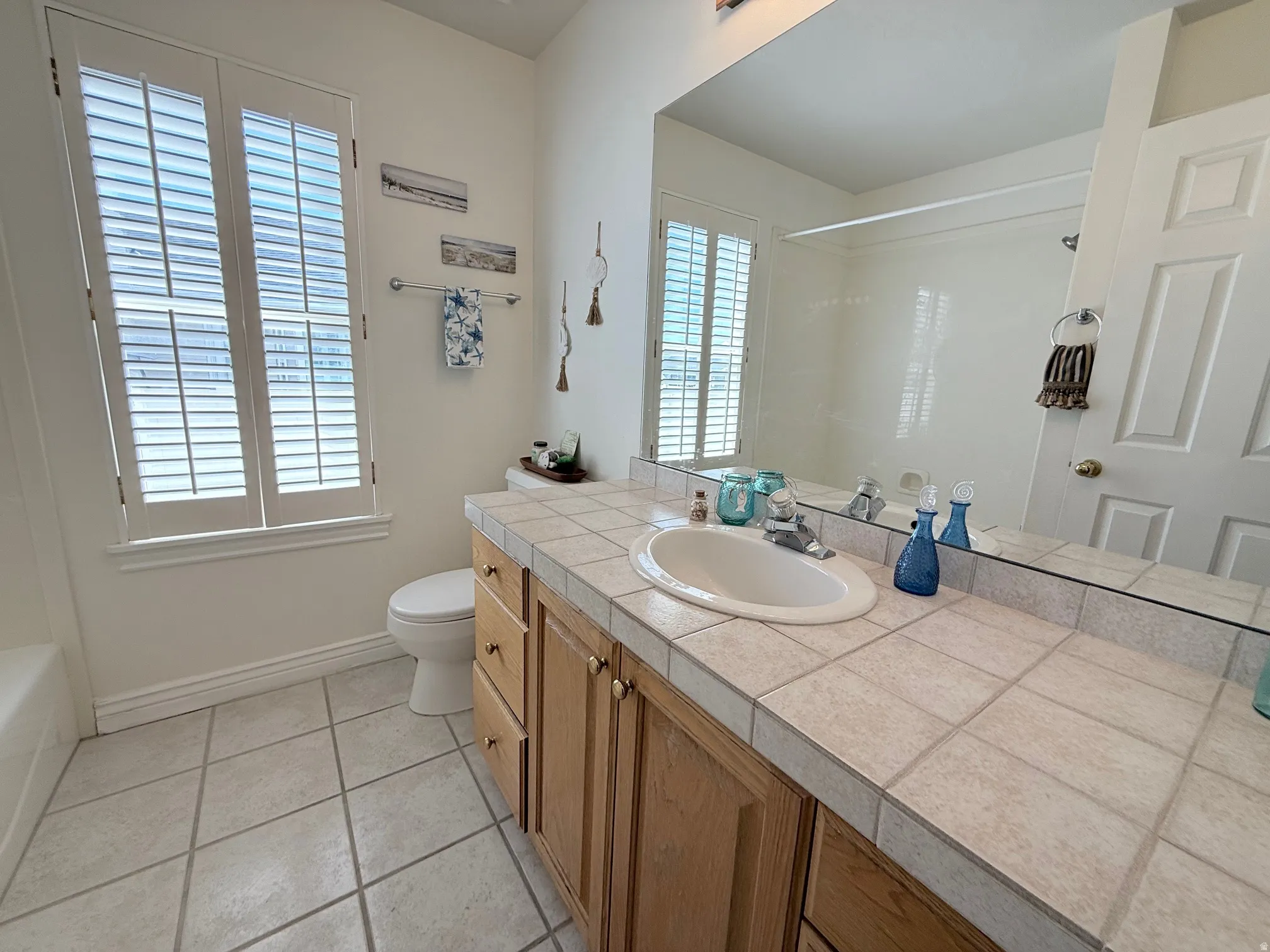 Bathroom with vanity, light tile patterned floors, a bathtub, and a shower
