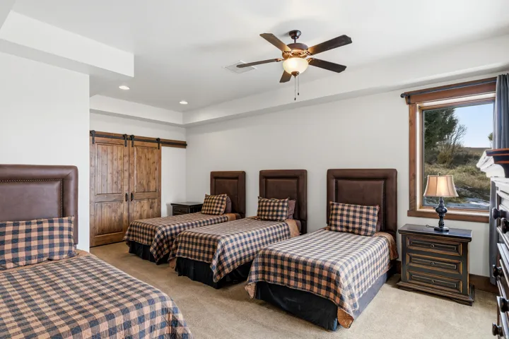 Bedroom with light carpet, a barn door, recessed lighting, and a ceiling fan