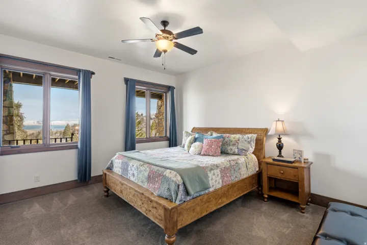 Bedroom with dark carpet and a ceiling fan