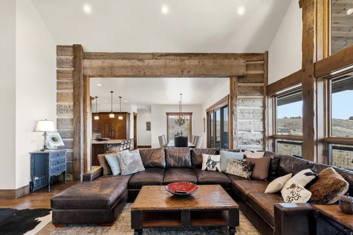 Living area featuring wood finished floors, a chandelier, and vaulted ceiling