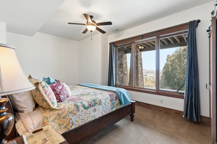 Bedroom with dark colored carpet and a ceiling fan