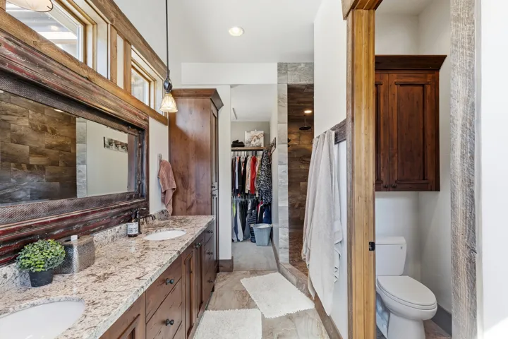 Full bath with double vanity, a shower stall, a spacious closet, and recessed lighting