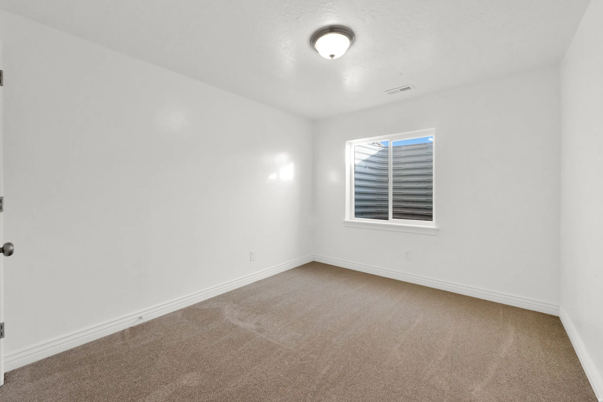 Carpeted empty room with baseboards