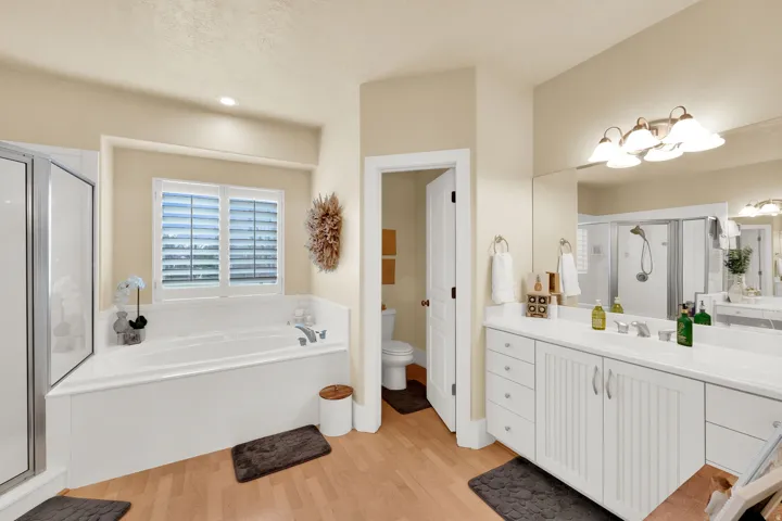 Full bathroom featuring a stall shower, vanity, light wood finished floors, and a bath