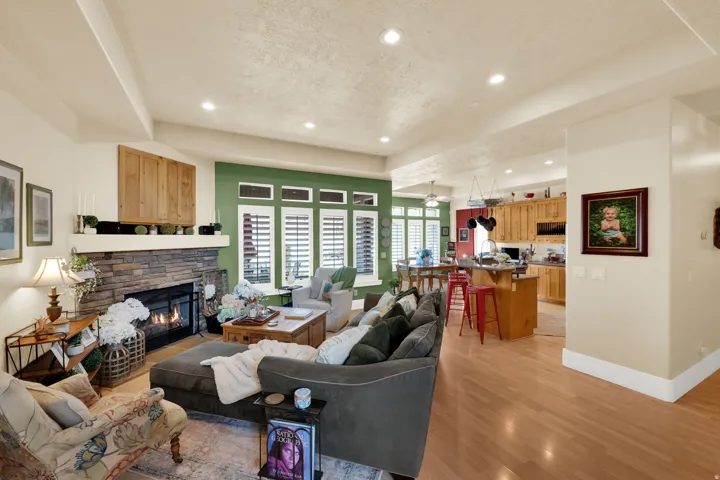 Living area with a stone fireplace, recessed lighting, light wood-style flooring, and a textured ceiling