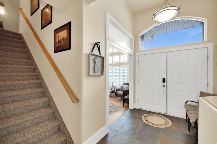 Foyer featuring stairway and stone tile flooring